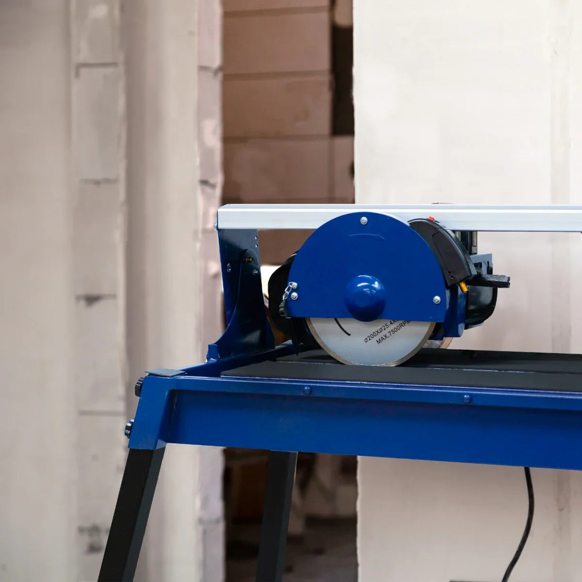 Wet tile cutter bench with a blue frame, 720mm cutting length, featuring a circular saw blade and sturdy black base for stability