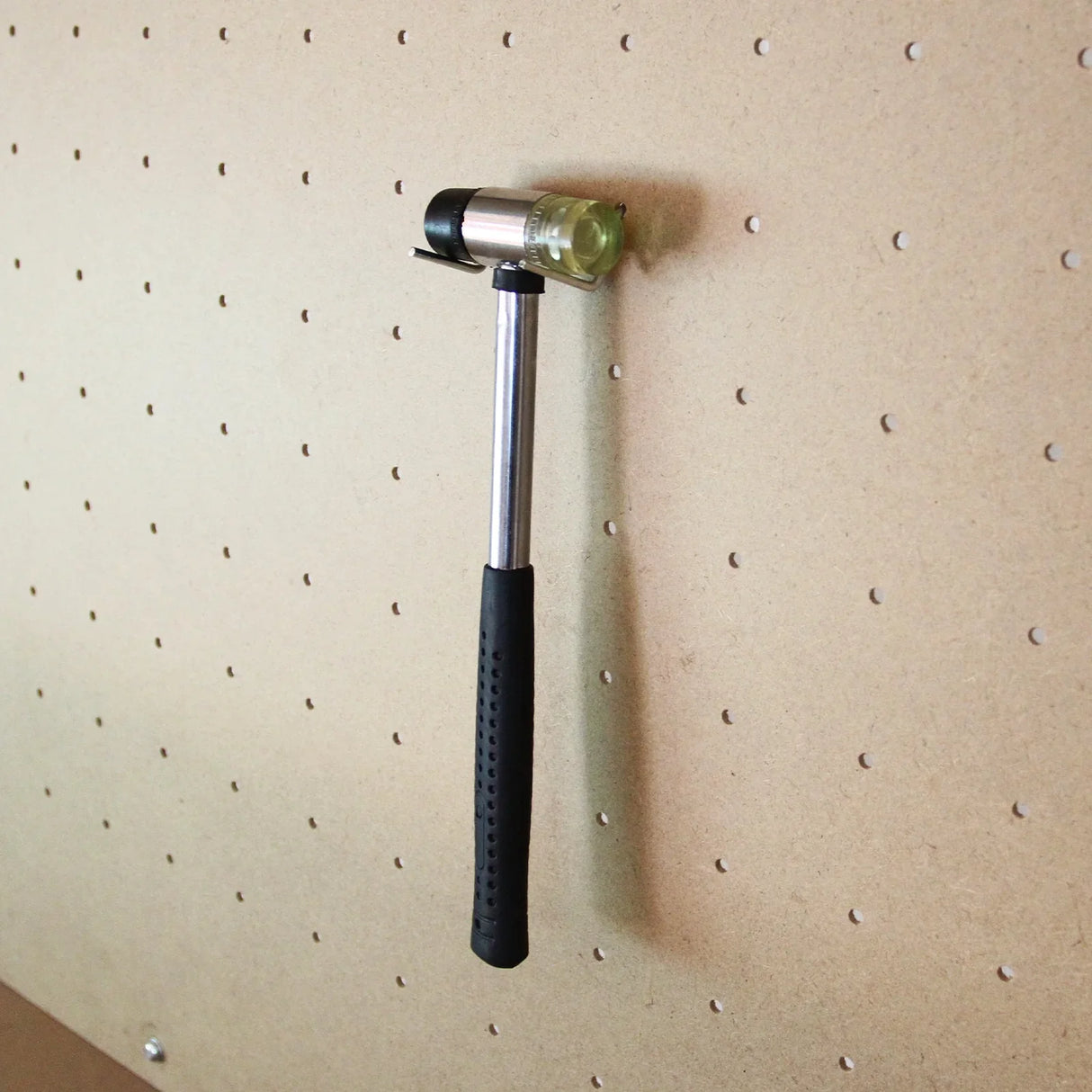 Red workbench featuring a pegboard with a hammer hanging, showcasing durable materials and practical design for organization
