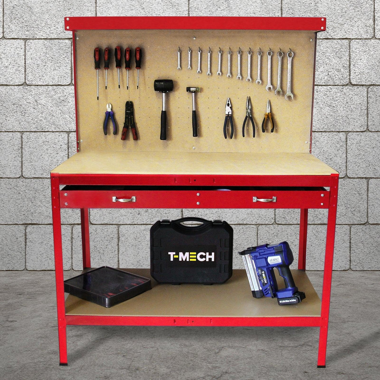 Red workbench with pegboard, tools hanging above, a drawer below, and a toolbox, set against a gray brick wall