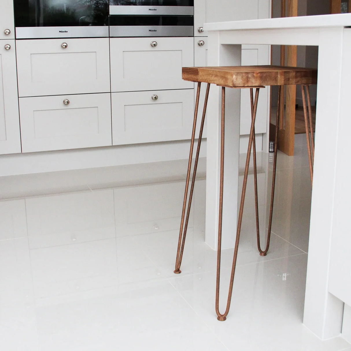 Antique copper hairpin legs, 28 inches tall, featuring a sleek, minimalist design, complementing a wooden table in a modern kitchen setting
