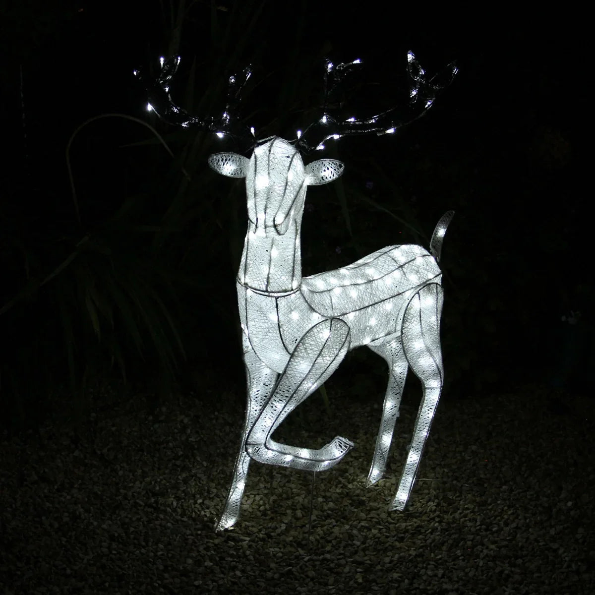 Glowing white reindeer sculpture with intricate wire design, illuminated with bright LED lights, perfect for festive outdoor decor