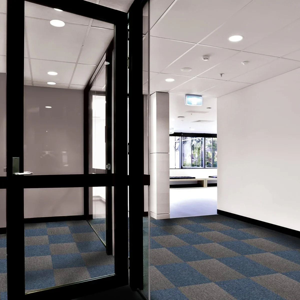 Storm blue and anthracite carpet tiles arranged in a modern hallway, showcasing a stylish checkerboard pattern and soft texture