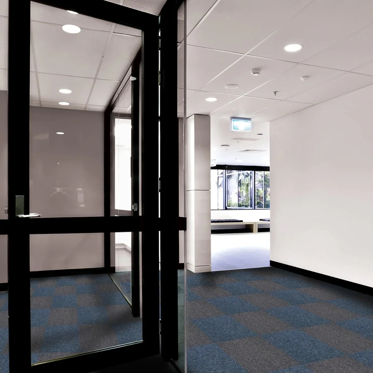 Storm blue and charcoal black carpet tiles arranged in a modern office space, showcasing a textured, stylish flooring option