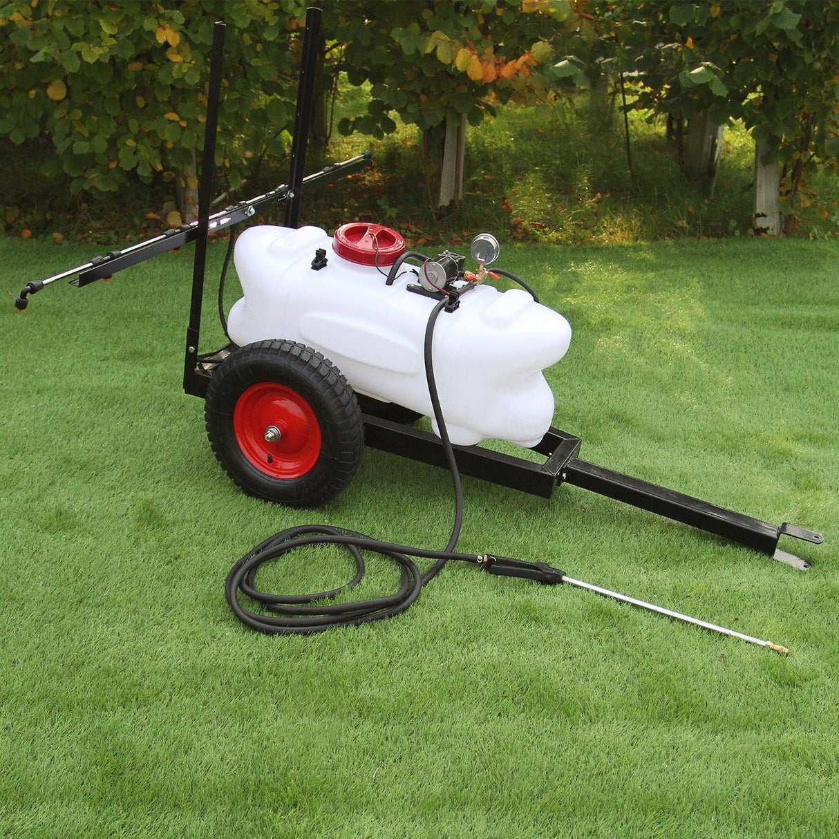 60L ATV trailer sprayer with a white tank, red cap, black frame, and large wheels, set on green grass with a spray wand attached
