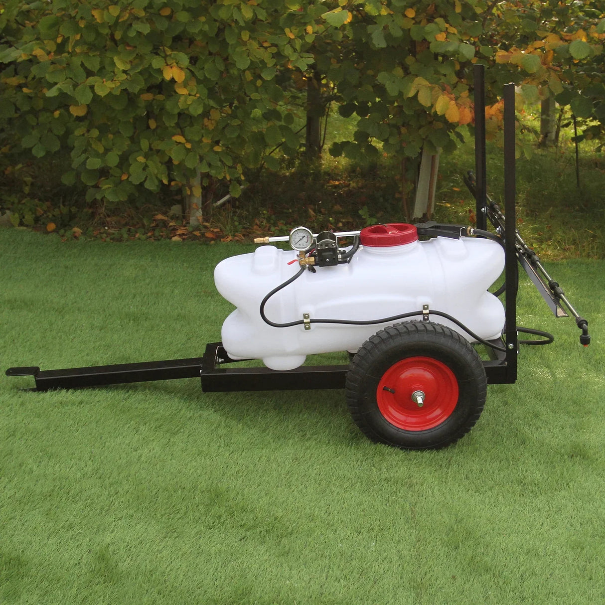 60L ATV trailer sprayer with a white tank, red cap, and black frame, featuring sturdy wheels for easy maneuverability on grass