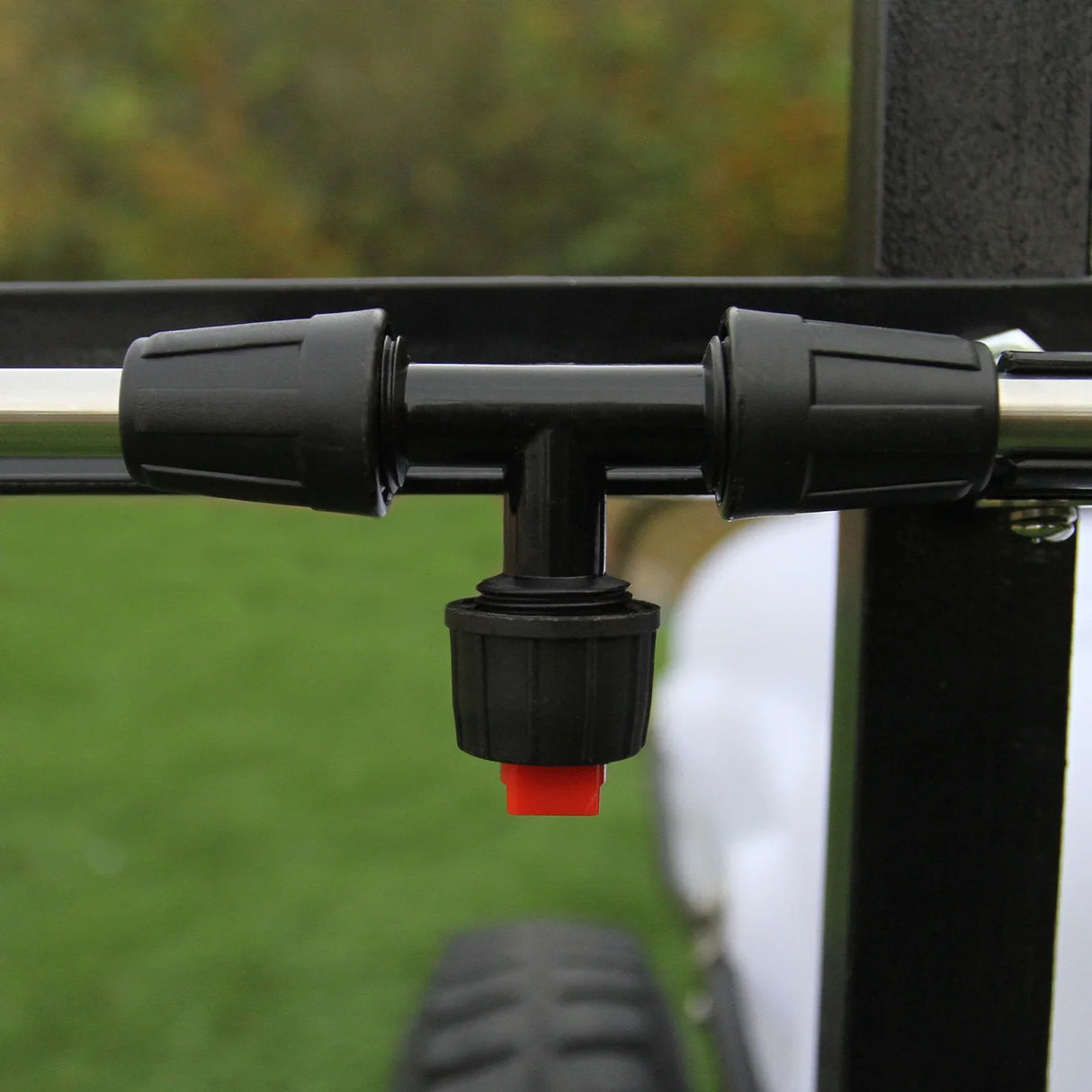 Black plastic sprayer nozzle with adjustable flow control, mounted on a metal frame, designed for the 60L ATV trailer and sprayer