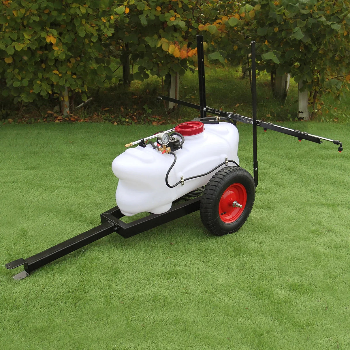 100L ATV trailer sprayer with a white tank, red cap, black frame, and sturdy wheels, set on green grass with trees in...