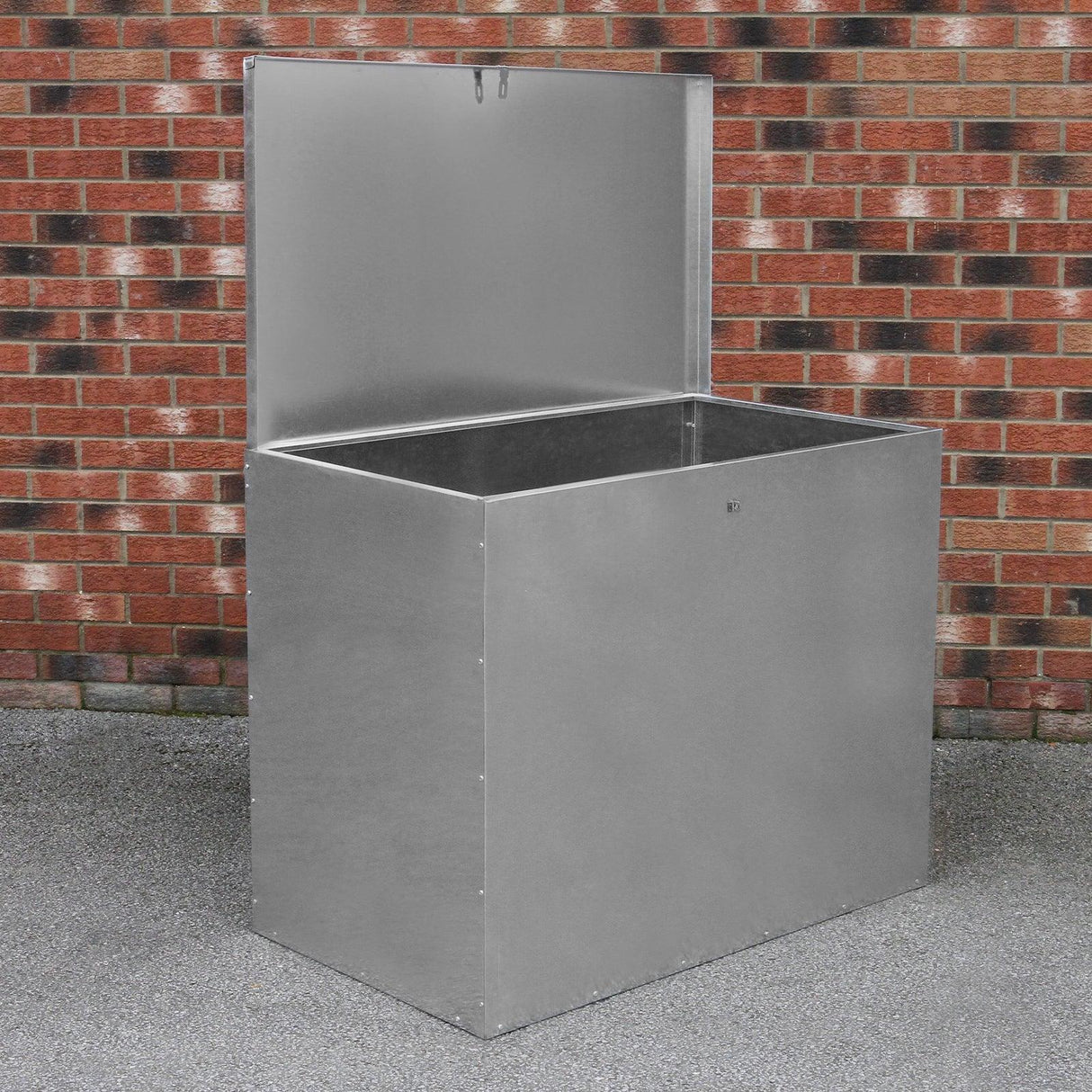 Galvanised feed store with a single compartment, featuring a shiny silver finish and a hinged lid, set against a brick wall background