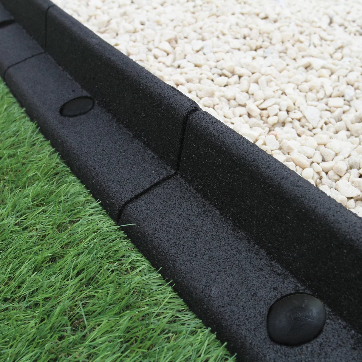 Flexible black lawn edging, 1.2m long, featuring a textured surface, designed to separate grass from gravel for a neat garden finish