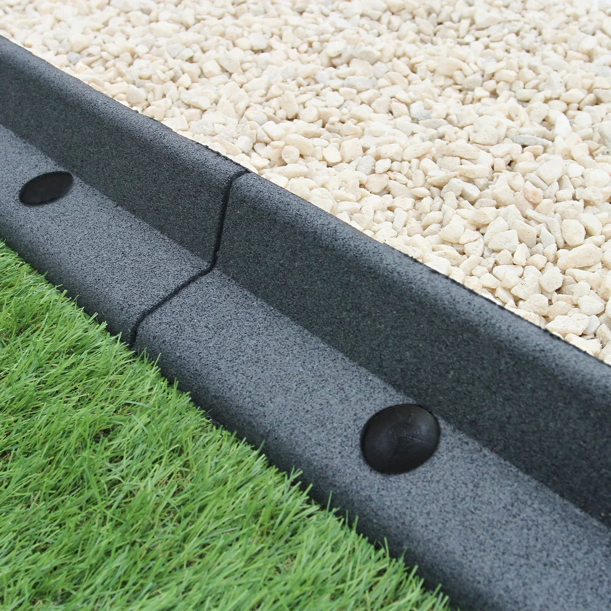 Flexible grey lawn edging, 1.2m long, featuring a smooth texture and rounded edges, separating gravel and grass areas