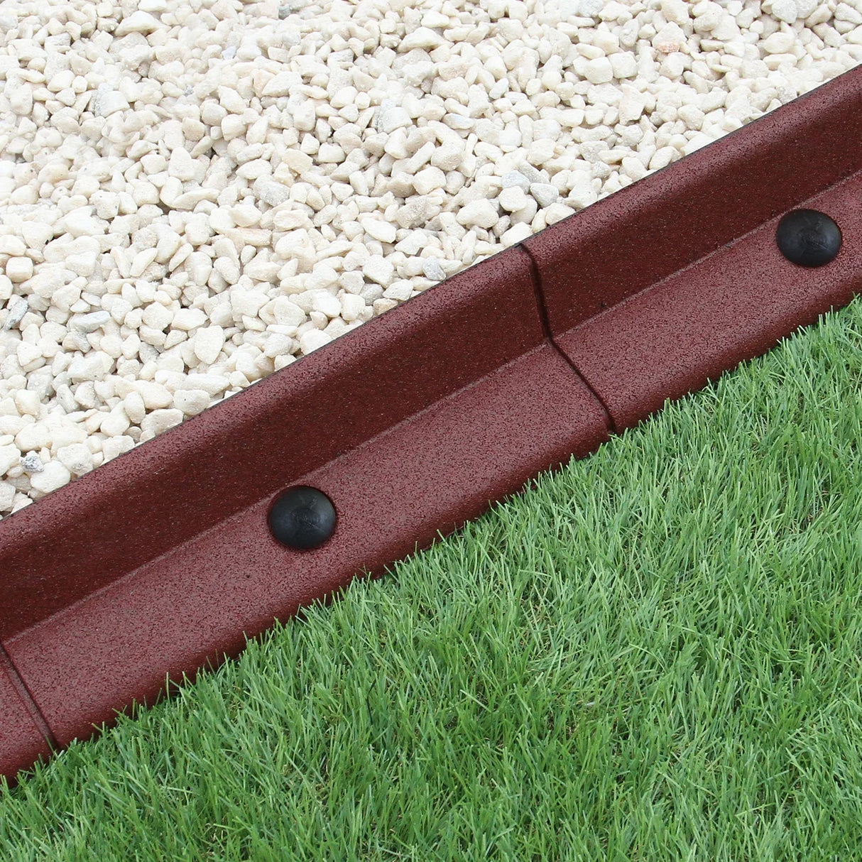 Flexible terracotta lawn edging, 1.2m long, featuring a textured surface, black connectors, and contrasting gravel and grass borders