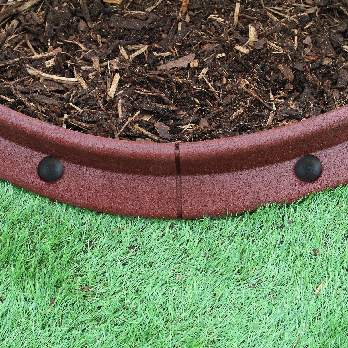 Flexible terracotta lawn edging, 1.2m long, featuring a smooth, curved design with black connectors, set against green grass and mulch