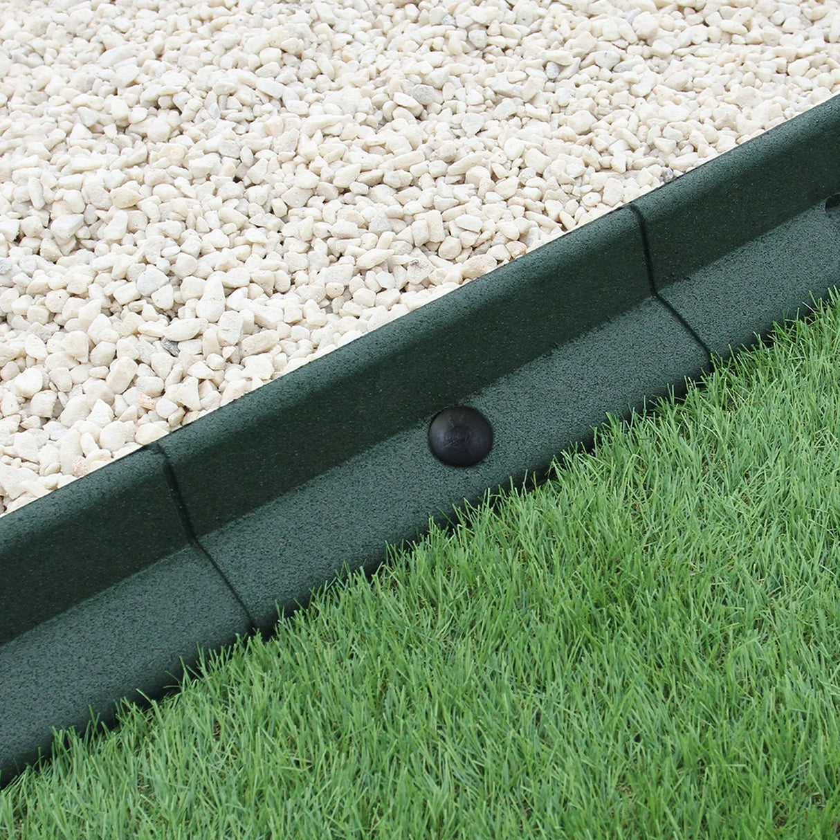 Flexible green lawn edging, 1.2m x 4, featuring a textured surface, neatly separating gravel and grass areas in a garden setting