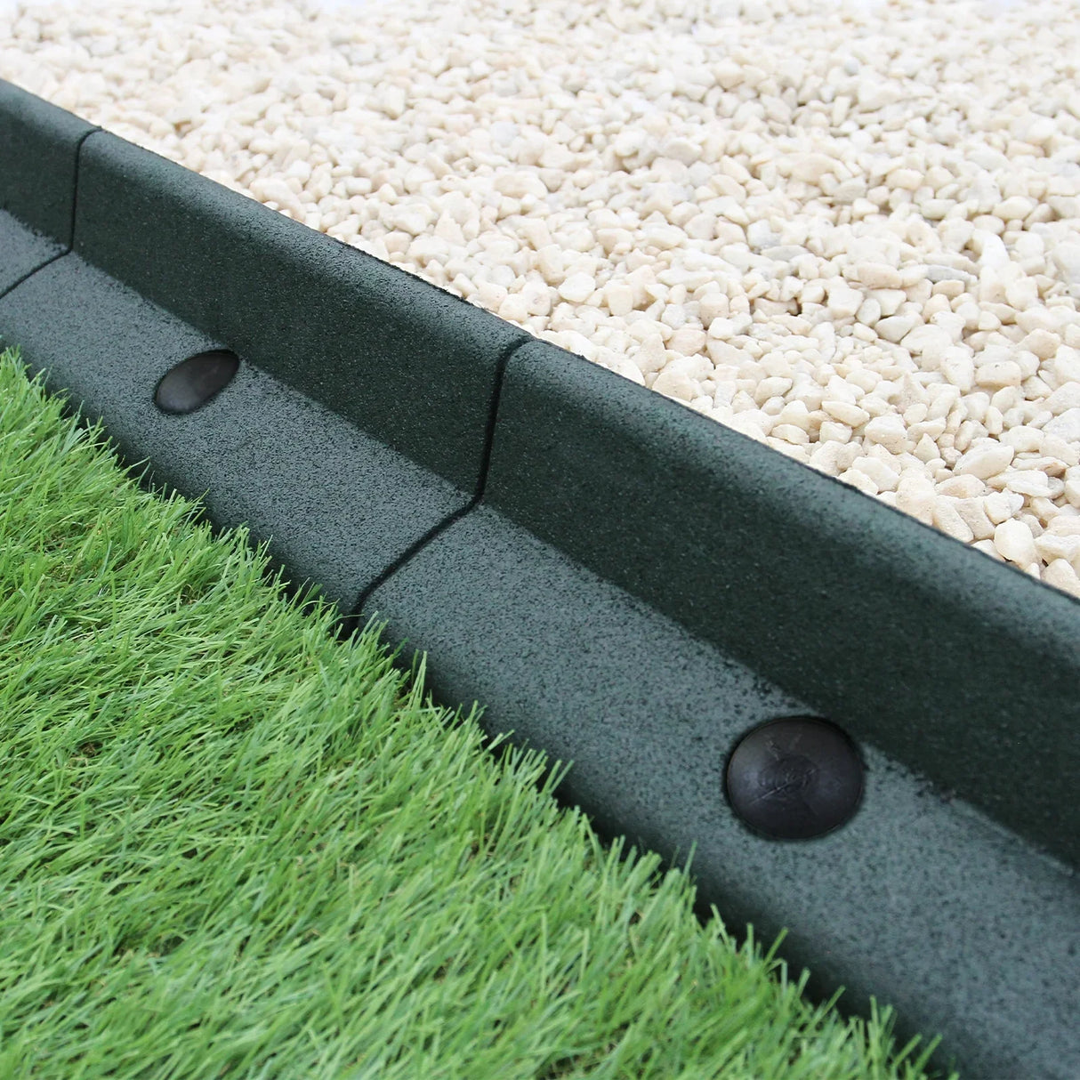 Flexible green lawn edging, 1.2m x 6, featuring a smooth texture and rounded shape, separating grass from gravel area
