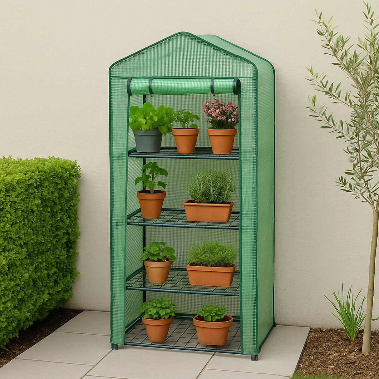 Four-tier greenhouse with a green PE cover, featuring potted plants and herbs on metal shelves, set against a garden backdrop