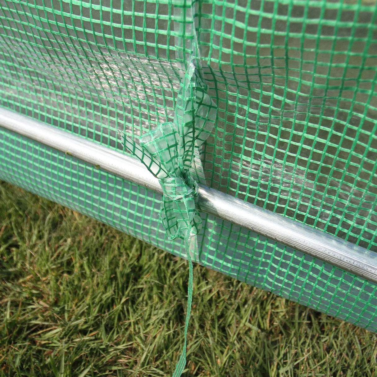 Close-up of the green mesh material and metal frame of a 3m x 2m Polytunnel, showcasing its durable construction and secure fastening
