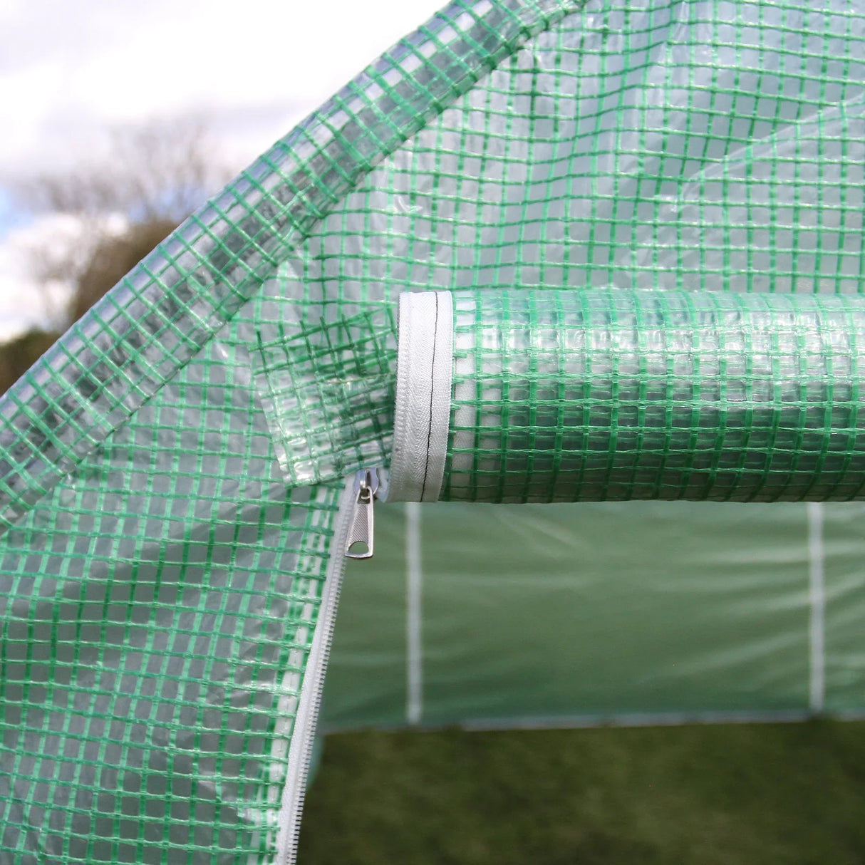 Close-up of the green mesh zipper detail on a 25mm polytunnel, showcasing its durable material and secure closure for optimal plant protection