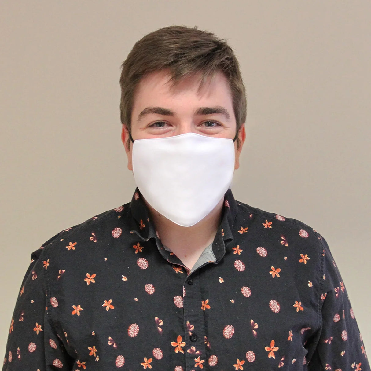 White sublimation blank face mask worn by a smiling man, showcasing a smooth texture against a patterned shirt background