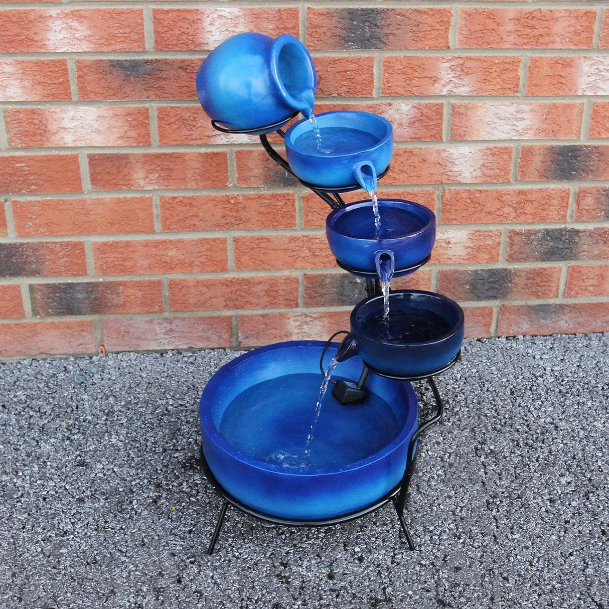 Four-tier blue spilling bowls water feature with a sleek black metal stand, cascading water from each bowl into the base