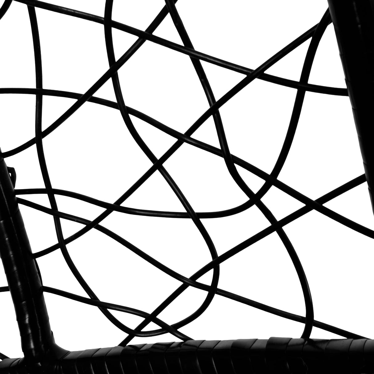 Intricate black rattan weaving forms the structure of a hanging egg chair, showcasing its modern design and unique texture