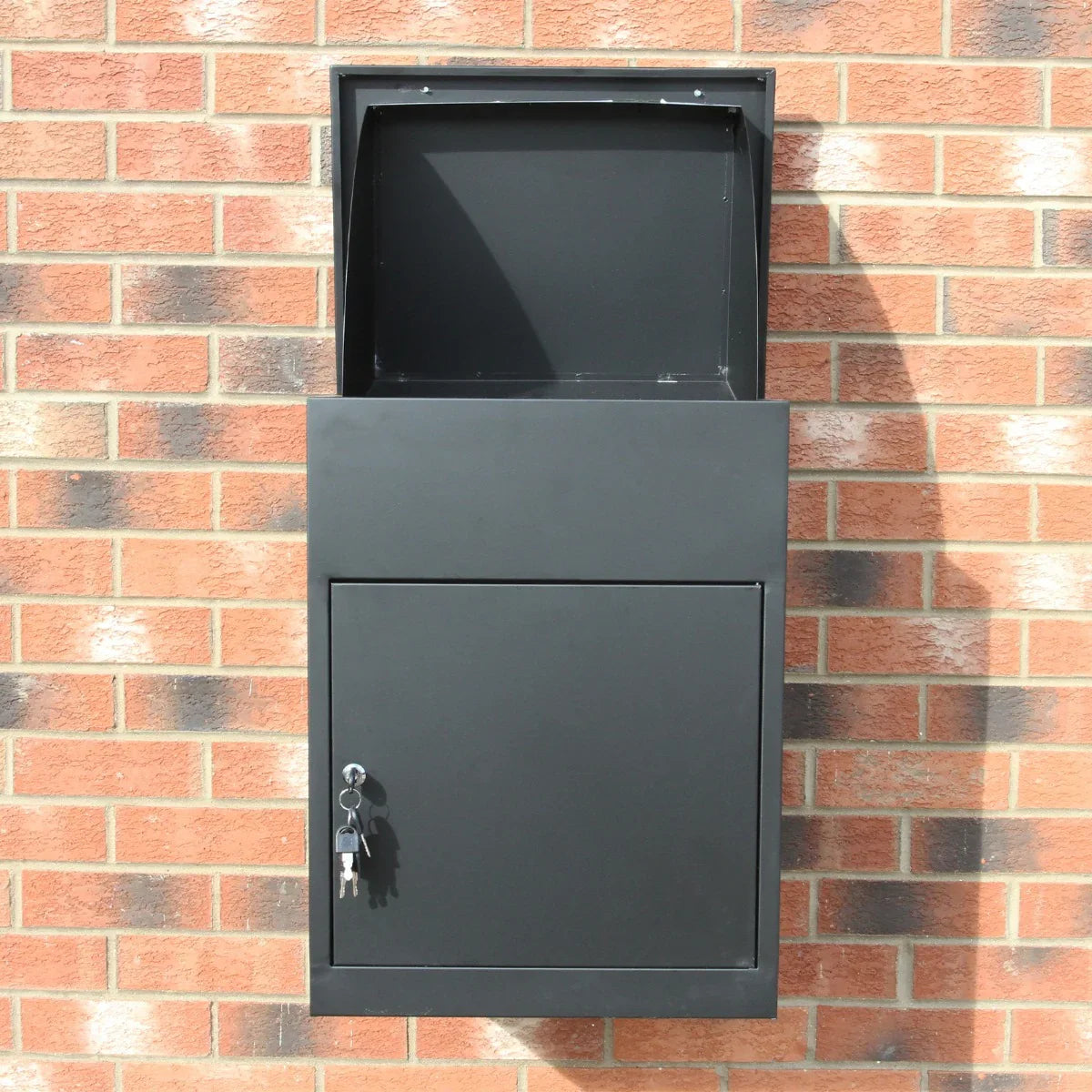 Sleek black parcel post box mounted on a brick wall, featuring a secure lock and an open top for easy package drop-off
