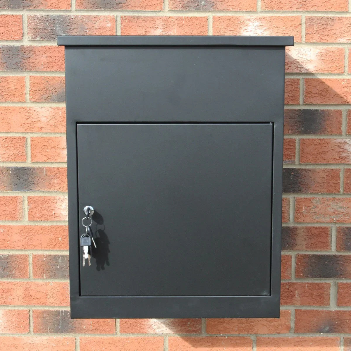 Sleek black parcel post box mounted on a brick wall, featuring a secure lock and key, ideal for safe package deliveries