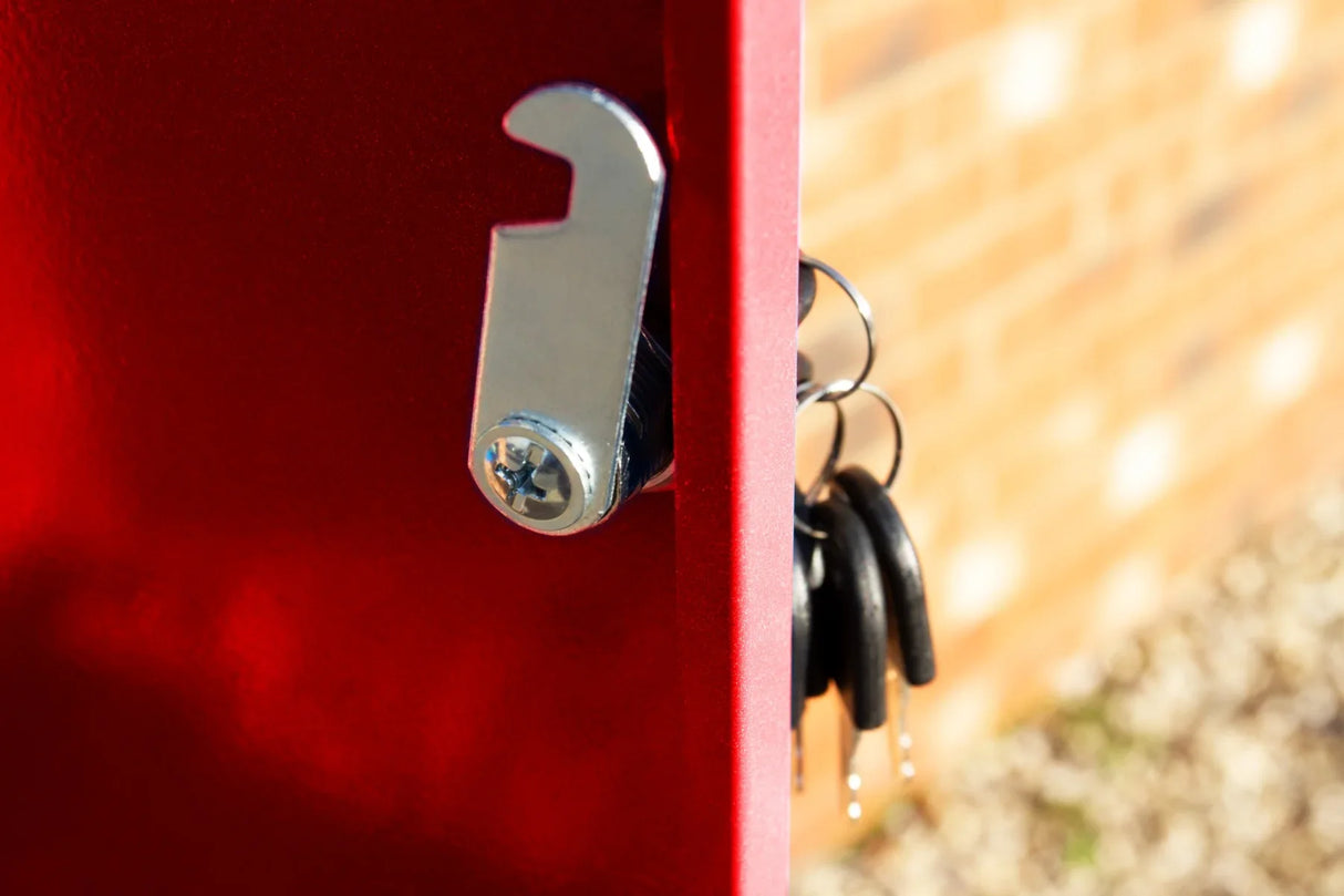 Close-up of a red parcel post box with a shiny metal latch and keys hanging from it, showcasing its durable design and vibrant color