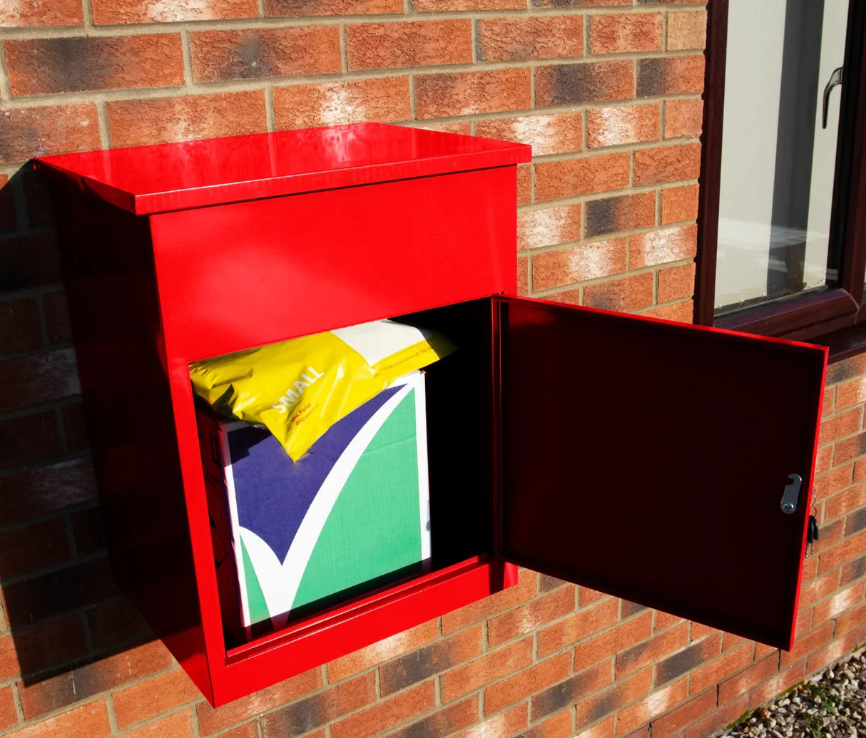 Bright red parcel post box mounted on a brick wall, featuring an open door revealing a package inside, showcasing its sturdy design