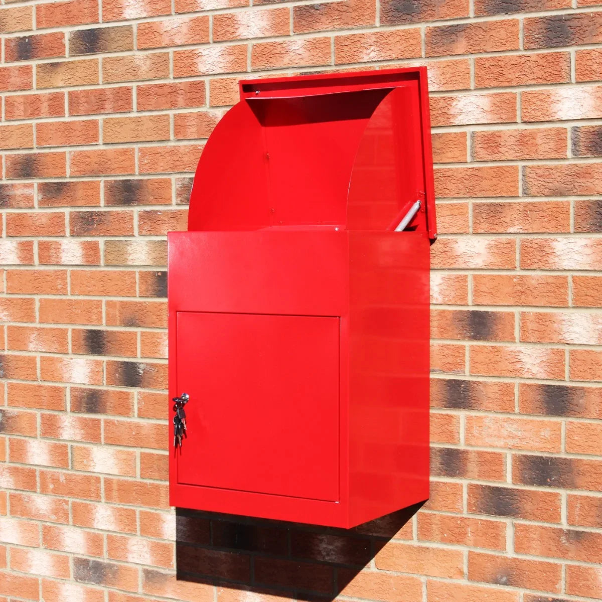 Bright red parcel post box mounted on a brick wall, featuring a curved top, secure lock, and spacious front opening for mail delivery
