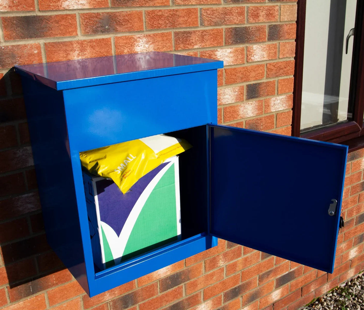 Bright blue parcel post box mounted on a brick wall, featuring an open door revealing a yellow and green package inside