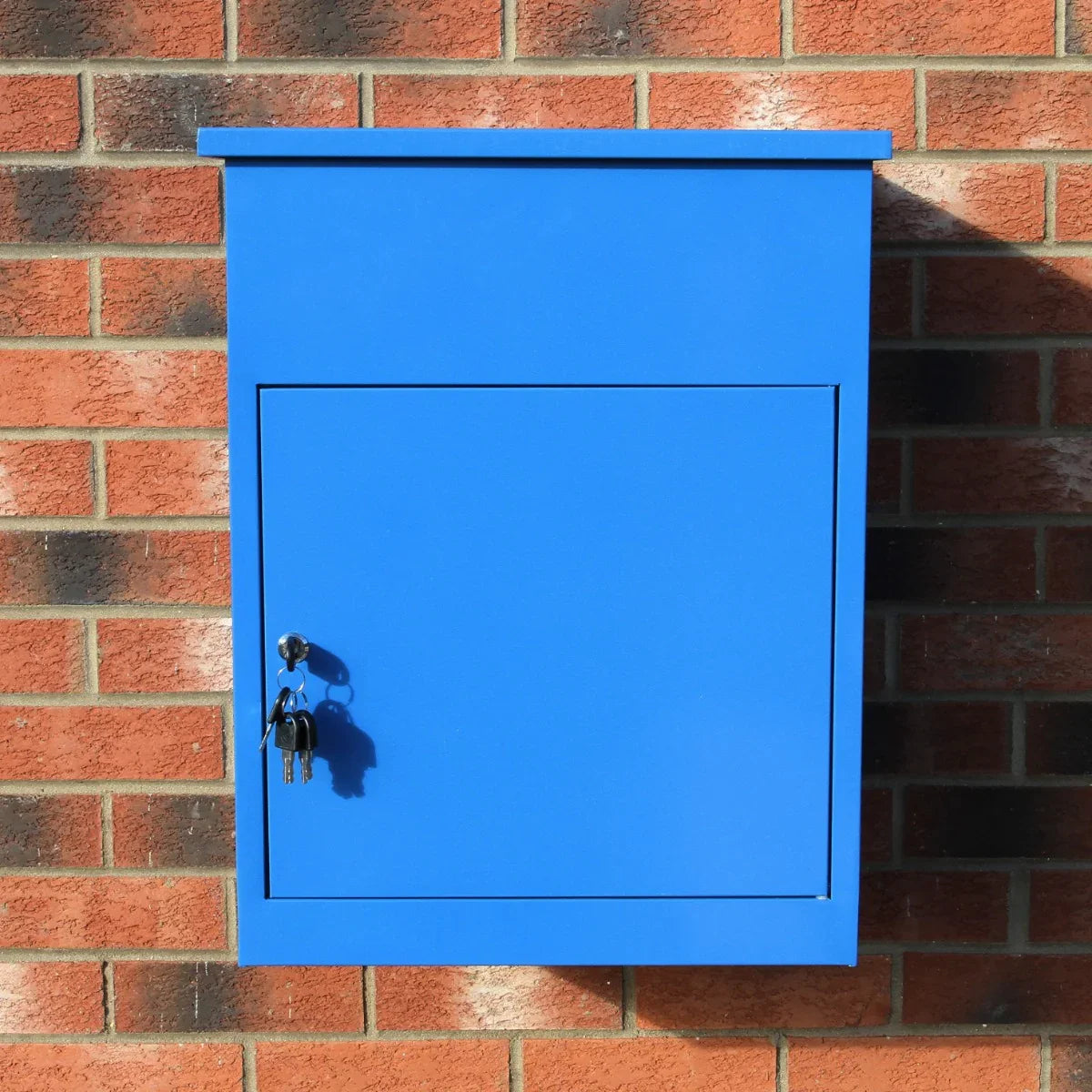 Bright blue parcel post box with a smooth finish, mounted on a brick wall, featuring a secure key lock and simple rectangular design