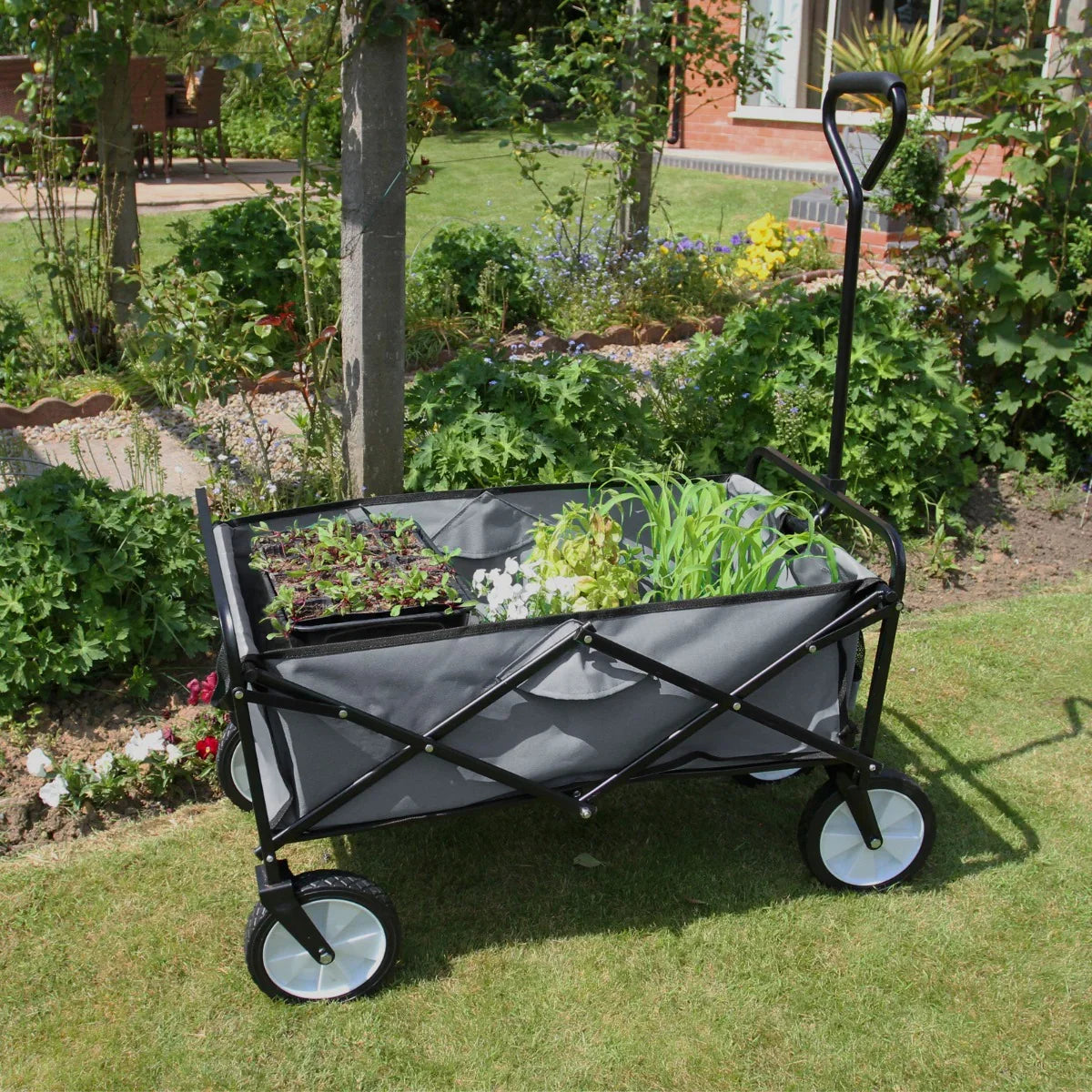 Foldable garden cart in grey with black frame, filled with plants, featuring sturdy wheels and a comfortable handle for easy transport