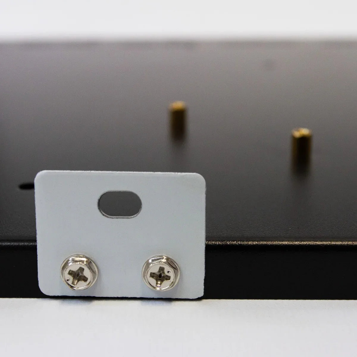 Close-up of a black metal GPU mining rig frame showing mounting holes and silver screws for secure installation and support