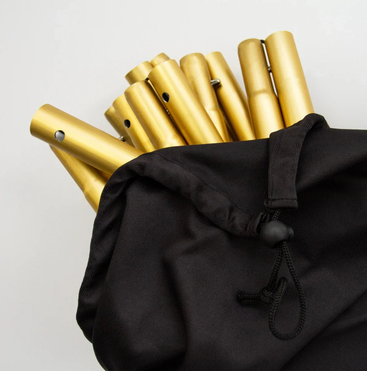 Gold wedding moongate assembly pieces in a black carrying bag, showcasing sleek metallic finish and sturdy design for elegant decor