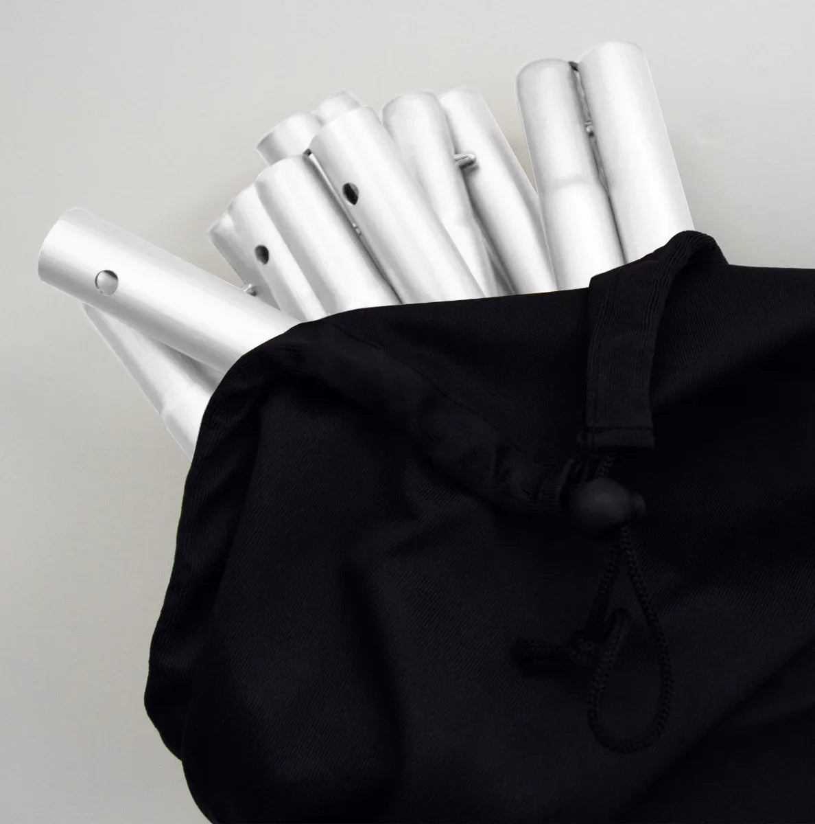 White Wedding Moongate 200cm components neatly packed in a black drawstring bag, showcasing sleek metal poles ready for assembly
