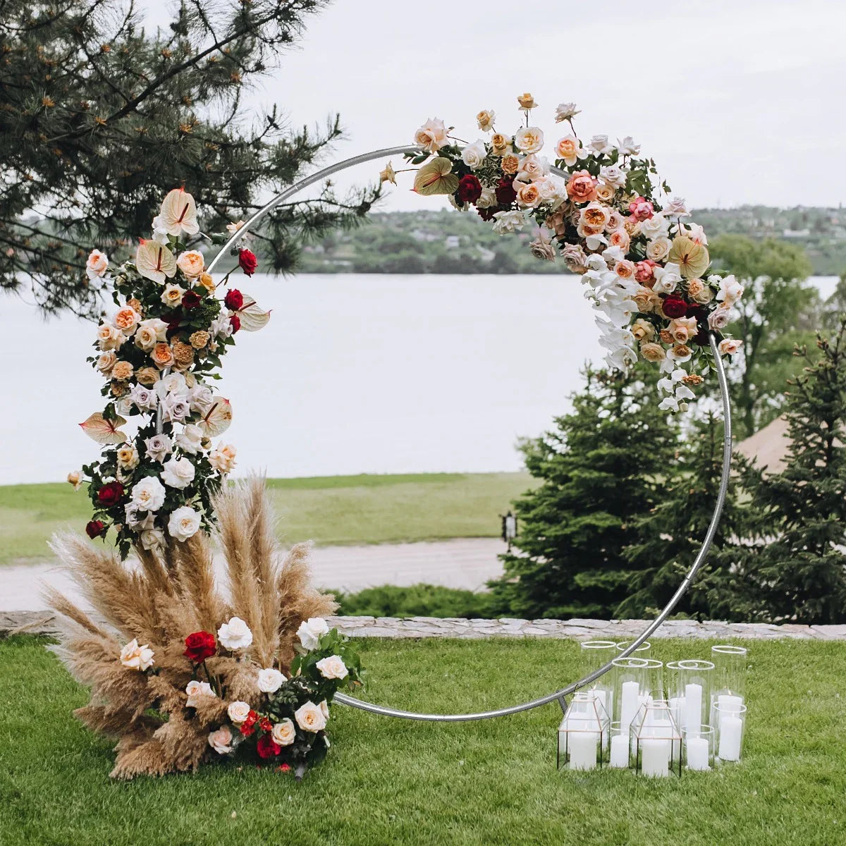 Elegant silver wedding moongate adorned with lush flowers and greenery, set against a serene lakeside backdrop, perfect for ceremonies