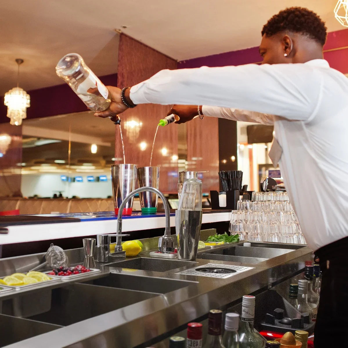 Stylish KuKoo Double Cocktail Bar Station with sleek stainless steel sink, vibrant bar setup, and bartender mixing drinks expertly