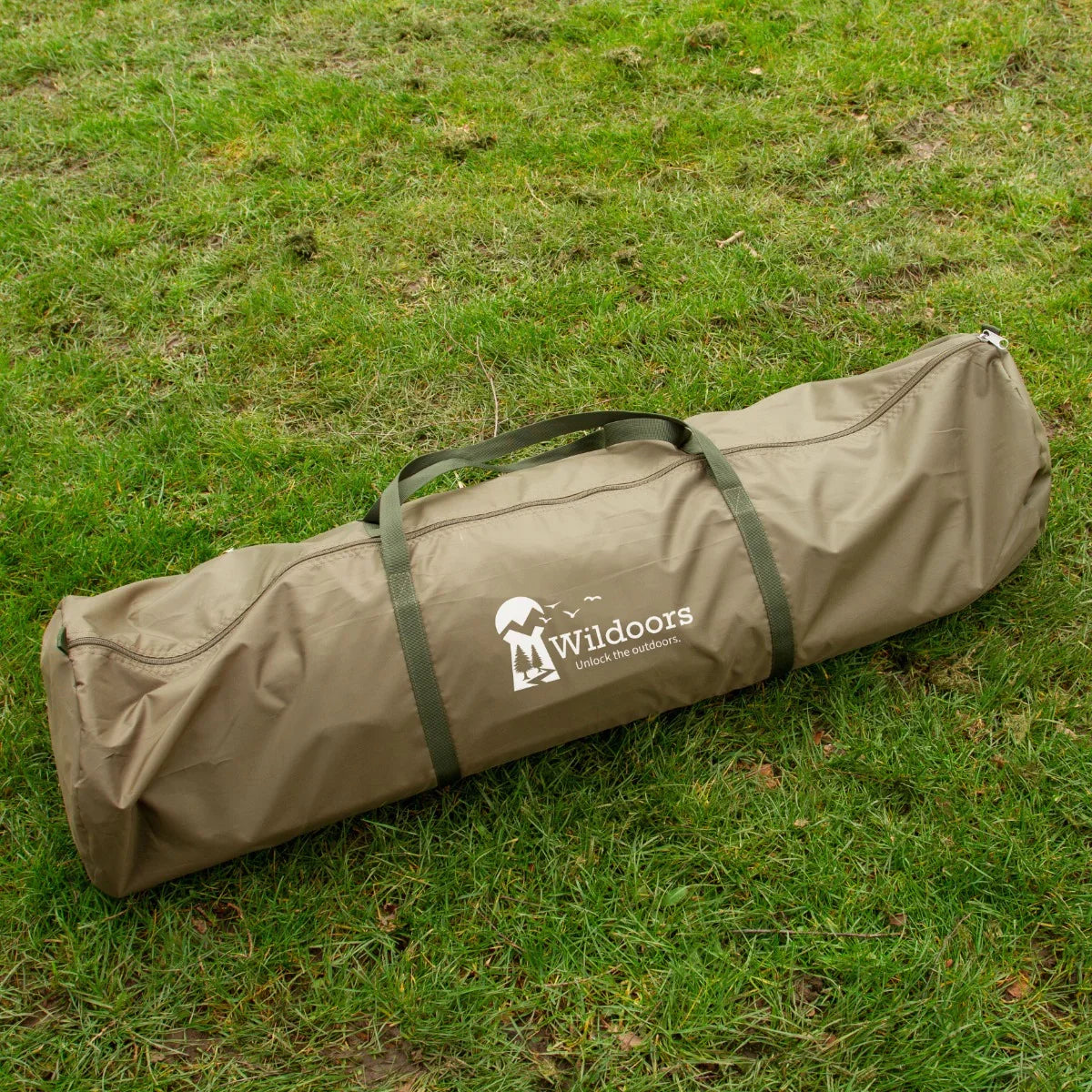 Olive green carrying bag for a 2-man fishing bivvy, featuring a sturdy handle and the Wildoors logo, resting on grass
