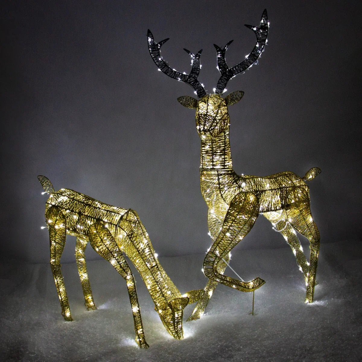 Light up gold stag and doe set with intricate wire design, illuminated by warm white lights, perfect for festive decor