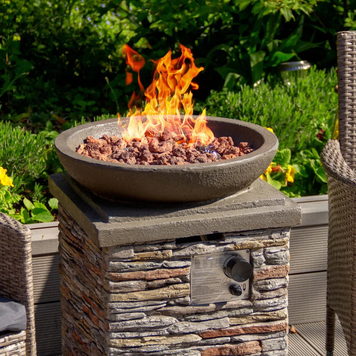 Stone gas fire pit heater with a round bowl, textured stone base, and vibrant flames over decorative lava rocks, perfect for outdoor gatherings