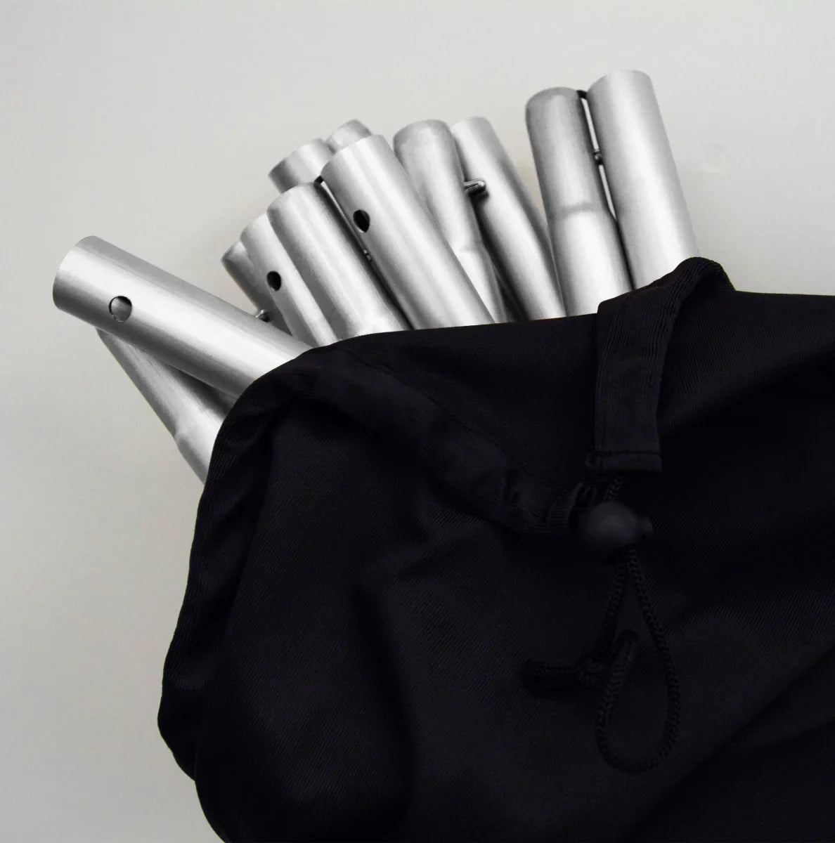 Silver wedding moongate assembly pieces neatly stored in a black drawstring bag, showcasing sleek metallic finish and smooth texture
