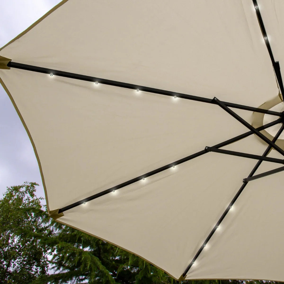 Cream 2.7m LED tilt parasol featuring a sturdy black frame, soft cream canopy, and integrated warm white lights for evening use