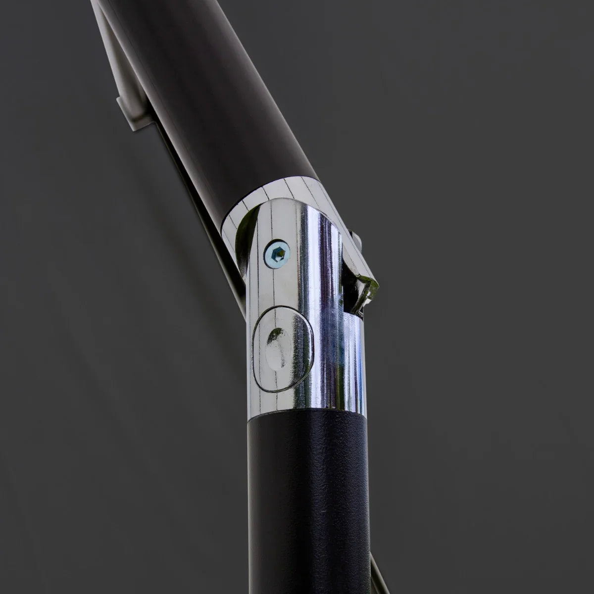 Close-up of the grey 2.7m LED tilt parasol's chrome hinge and sturdy black pole, showcasing its durable design and functionality