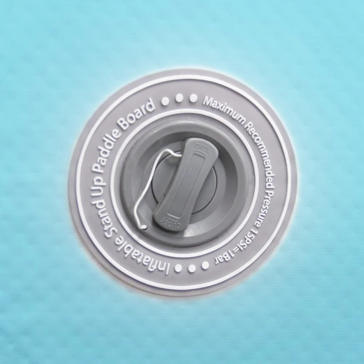 Gray valve on a textured blue surface of a 10ft inflatable paddle board, indicating maximum pressure settings for use