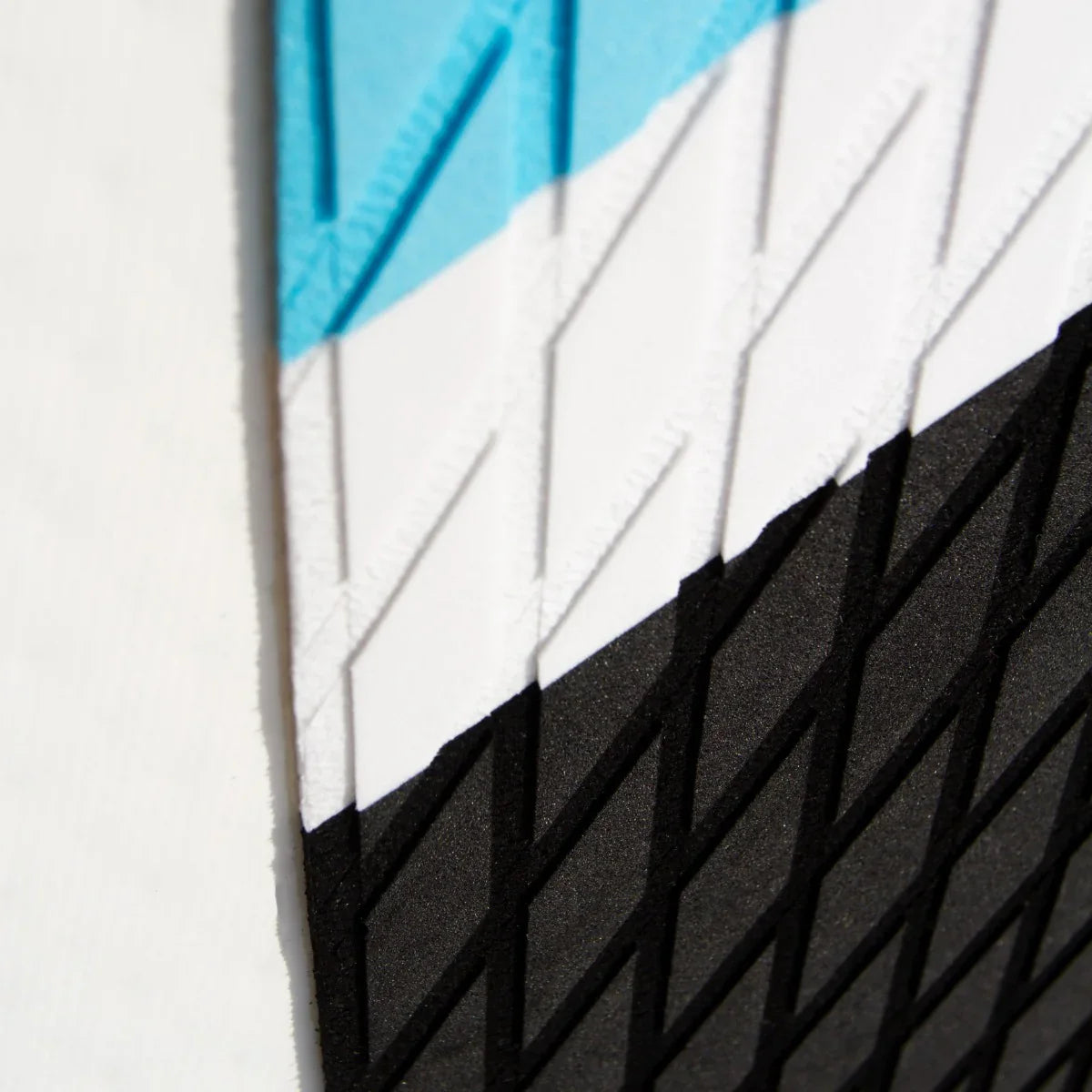 Close-up of textured surface on a blue inflatable paddle board, featuring a black, white, and light blue color scheme
