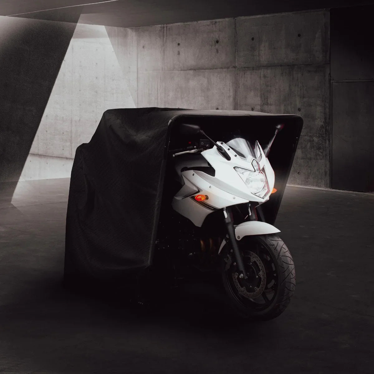 Motorbike tent featuring a sleek black cover, designed to protect motorcycles, with a modern, minimalist backdrop and soft lighting