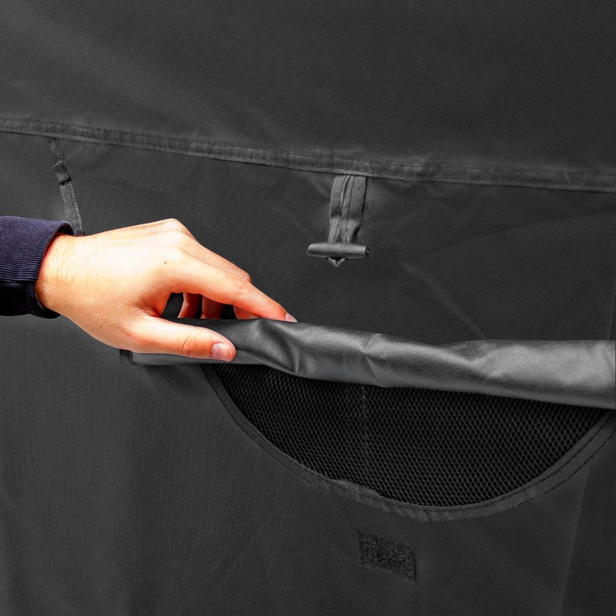 Large motorbike tent featuring a hand adjusting the mesh pocket, showcasing durable black fabric and practical design elements