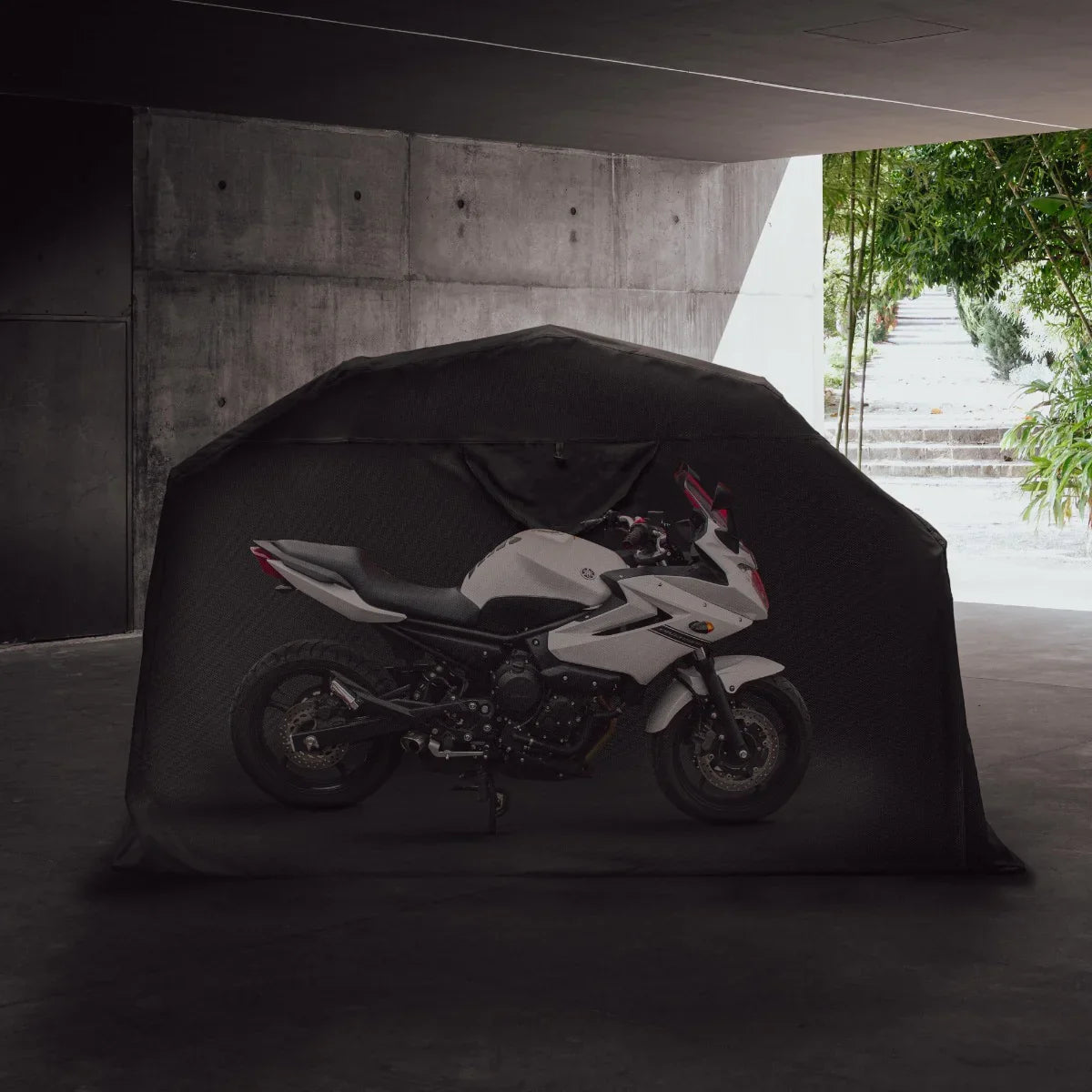 Large motorbike tent in black, showcasing a sleek white motorcycle inside, set against a modern concrete backdrop