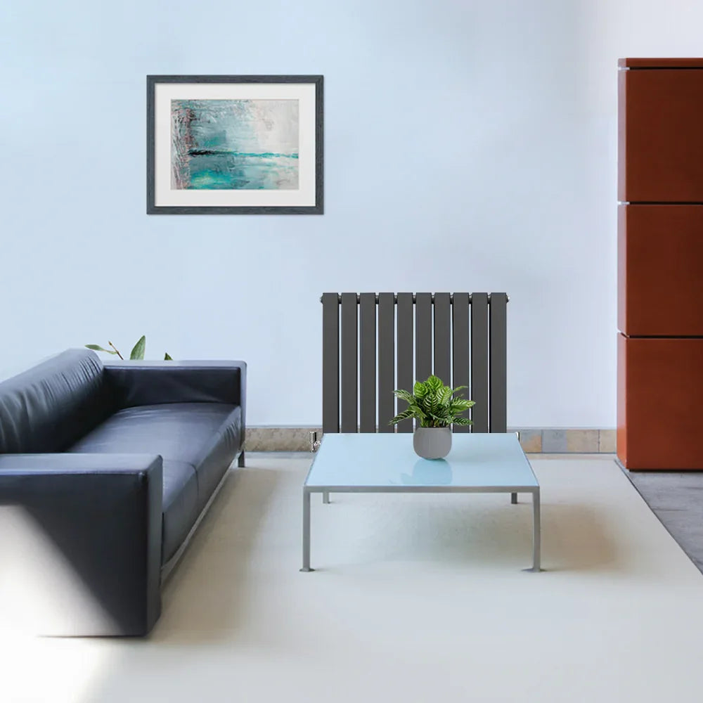 Anthracite grey designer flat panel radiator in a modern living room, featuring sleek lines and a minimalist design against a light wall