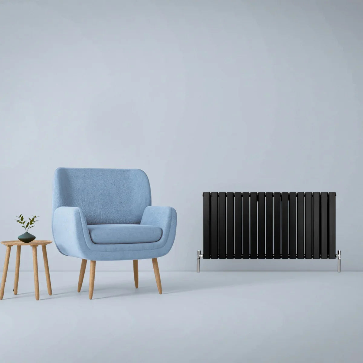 Matt black designer flat panel radiator, 600mm x 1190mm, sleek vertical design, paired with a light blue armchair and wooden side table